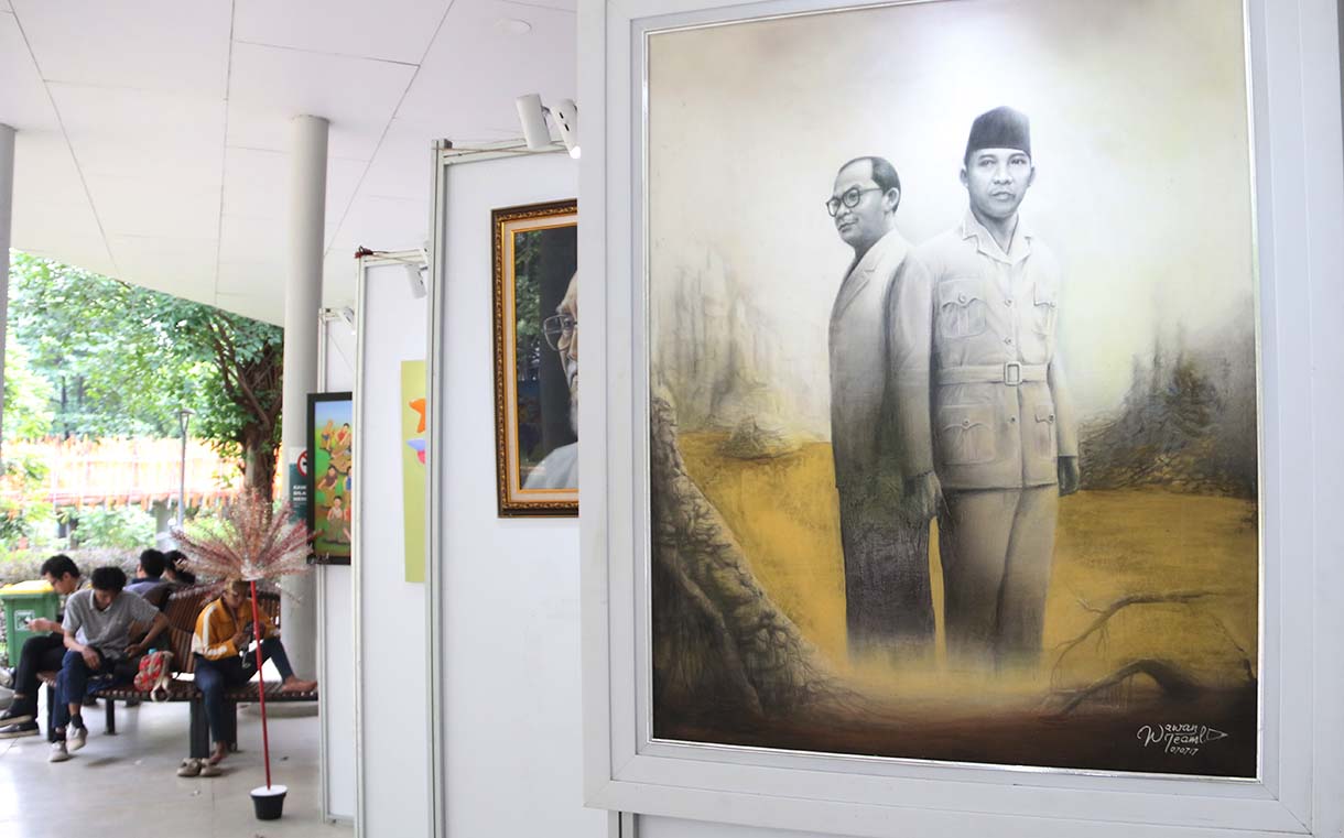 Pengunjung mengamati lukisan dalam pameran Jakarta Artmosphere 2025 di Tebet Eco Park, Jakarta, Selasa (21/10/2025).  (Beritanasional.com/Okeatmaja)