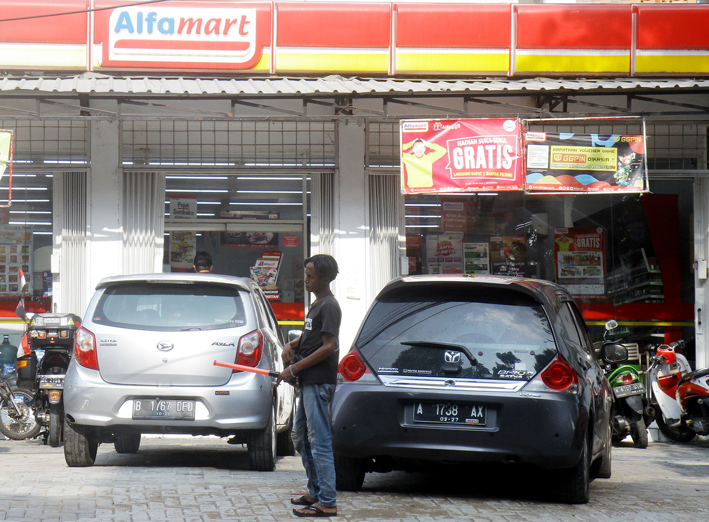 Juru parkir memarkirkan kendaraan di salah satu minimarket di kawasan Jakarta, Senin (13/5/2024).  (BeritaNasional.com/Oke Atmaja)