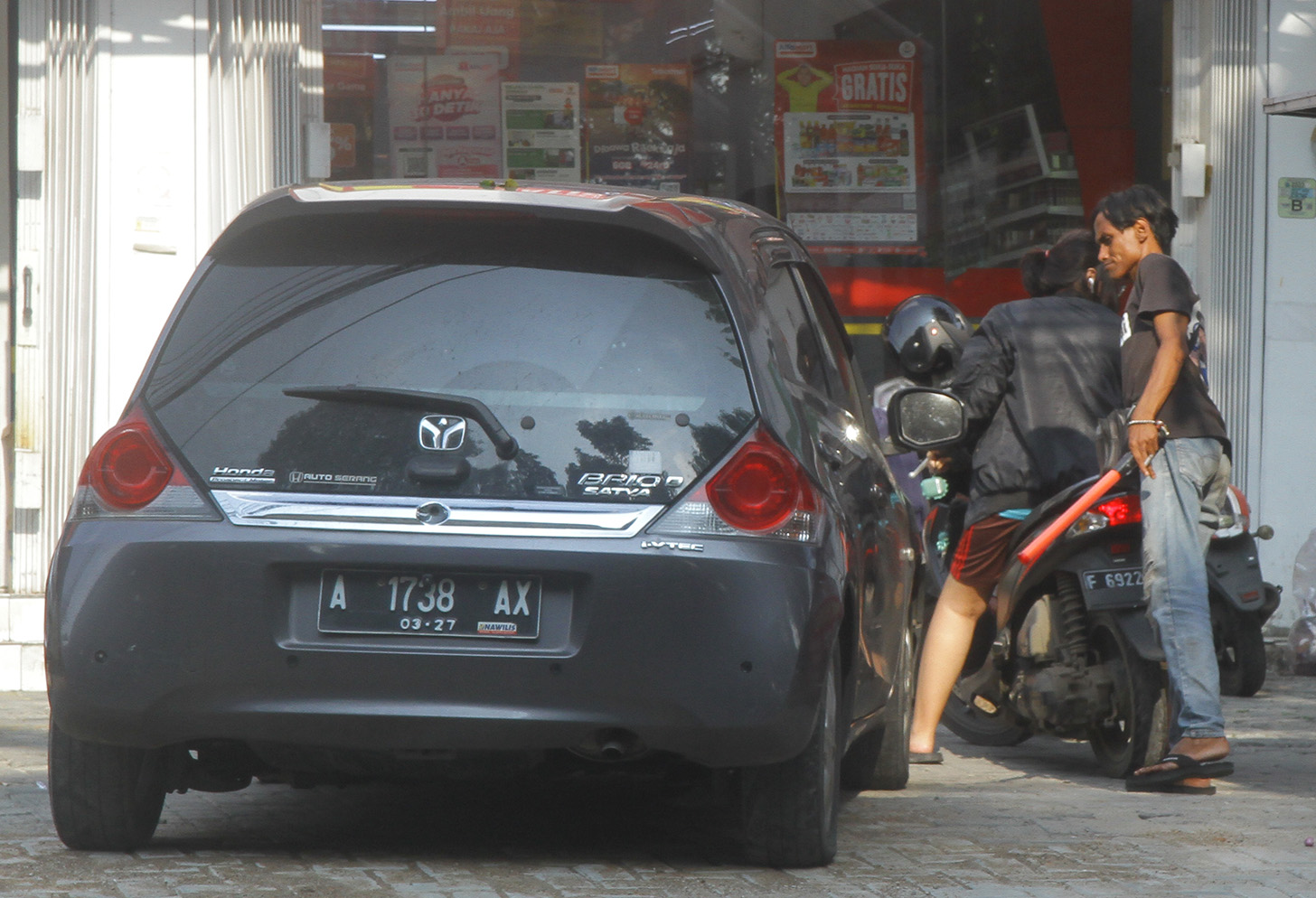 Juru parkir memarkirkan kendaraan di salah satu minimarket di kawasan Jakarta, Senin (13/5/2024).  (BeritaNasional.com/Oke Atmaja)