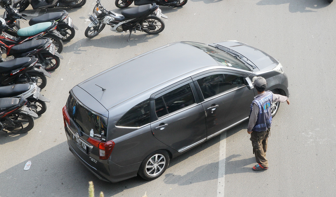 Kendaraan sepeda motor dan mobil yang diparkir di bahu jalan di sekitar Jalan Pramuka, Jakarta, Selasa (21/5/2024). (BeritaNasional.Com/Oke Atmaja)