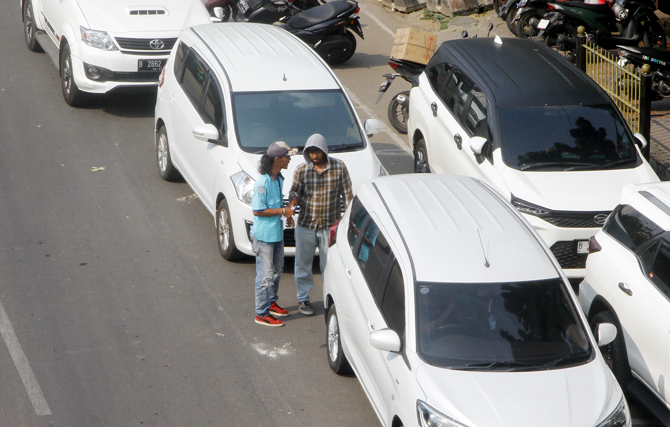 Kendaraan sepeda motor dan mobil yang diparkir di bahu jalan di sekitar Jalan Pramuka, Jakarta, Selasa (21/5/2024). (BeritaNasional.Com/Oke Atmaja)