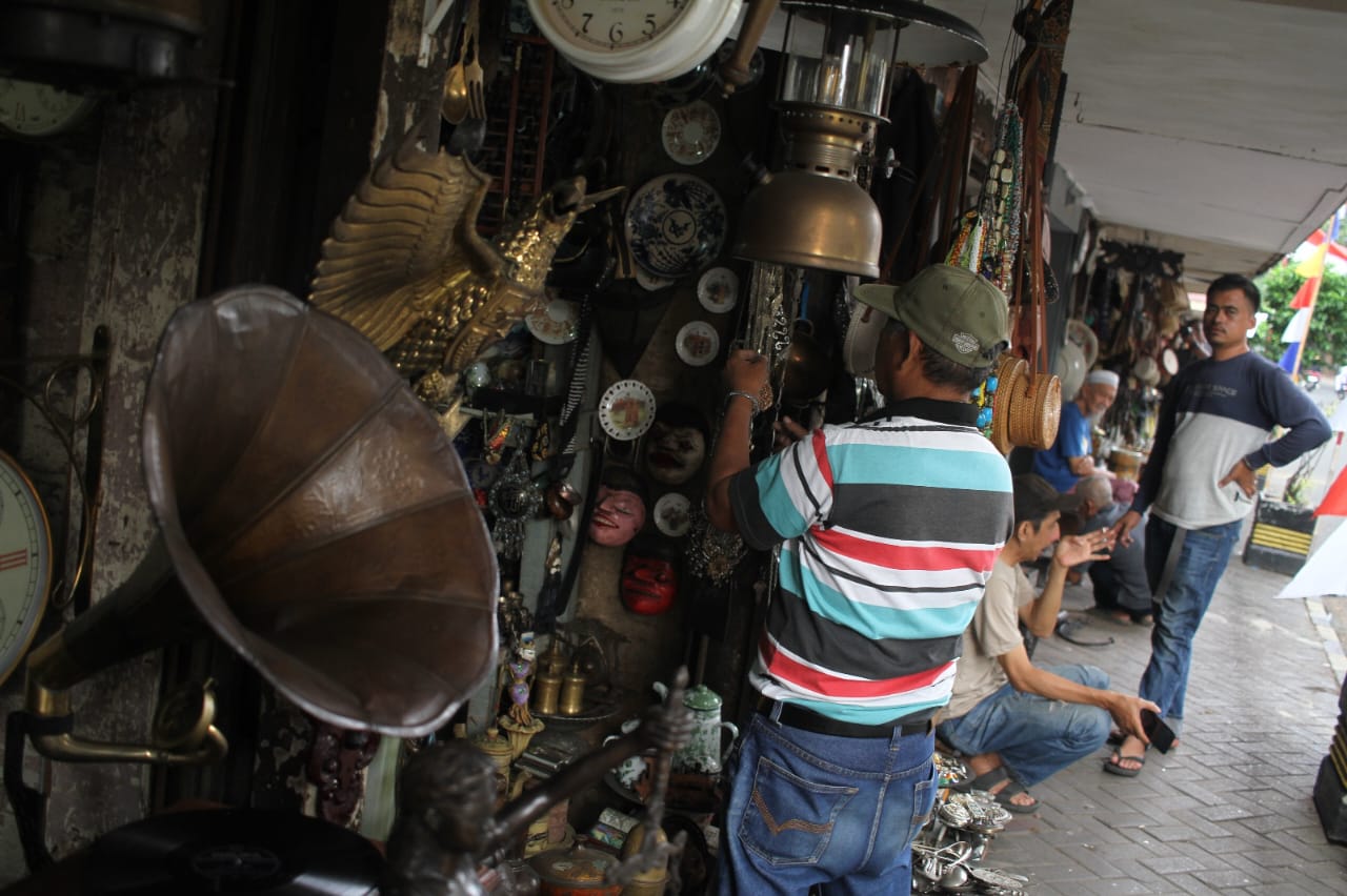 Penjual membersihkan barang dagangannya di Sentra Penjualan Barang Antik Jalan Surabaya, Menteng, Jakarta, Kamis (21/8/2025).  (Beritanasional.com/Oke Atmaja)