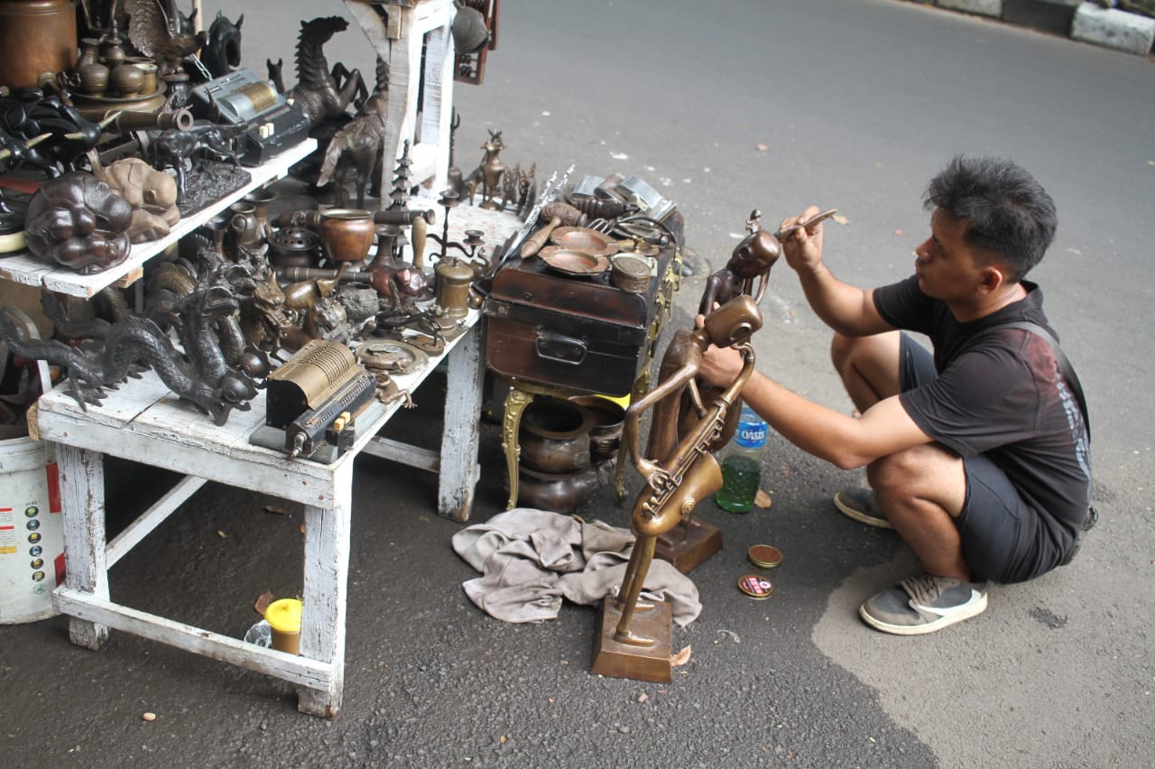 Penjual membersihkan barang dagangannya di Sentra Penjualan Barang Antik Jalan Surabaya, Menteng, Jakarta, Kamis (21/8/2025).  (Beritanasional.com/Oke Atmaja)
