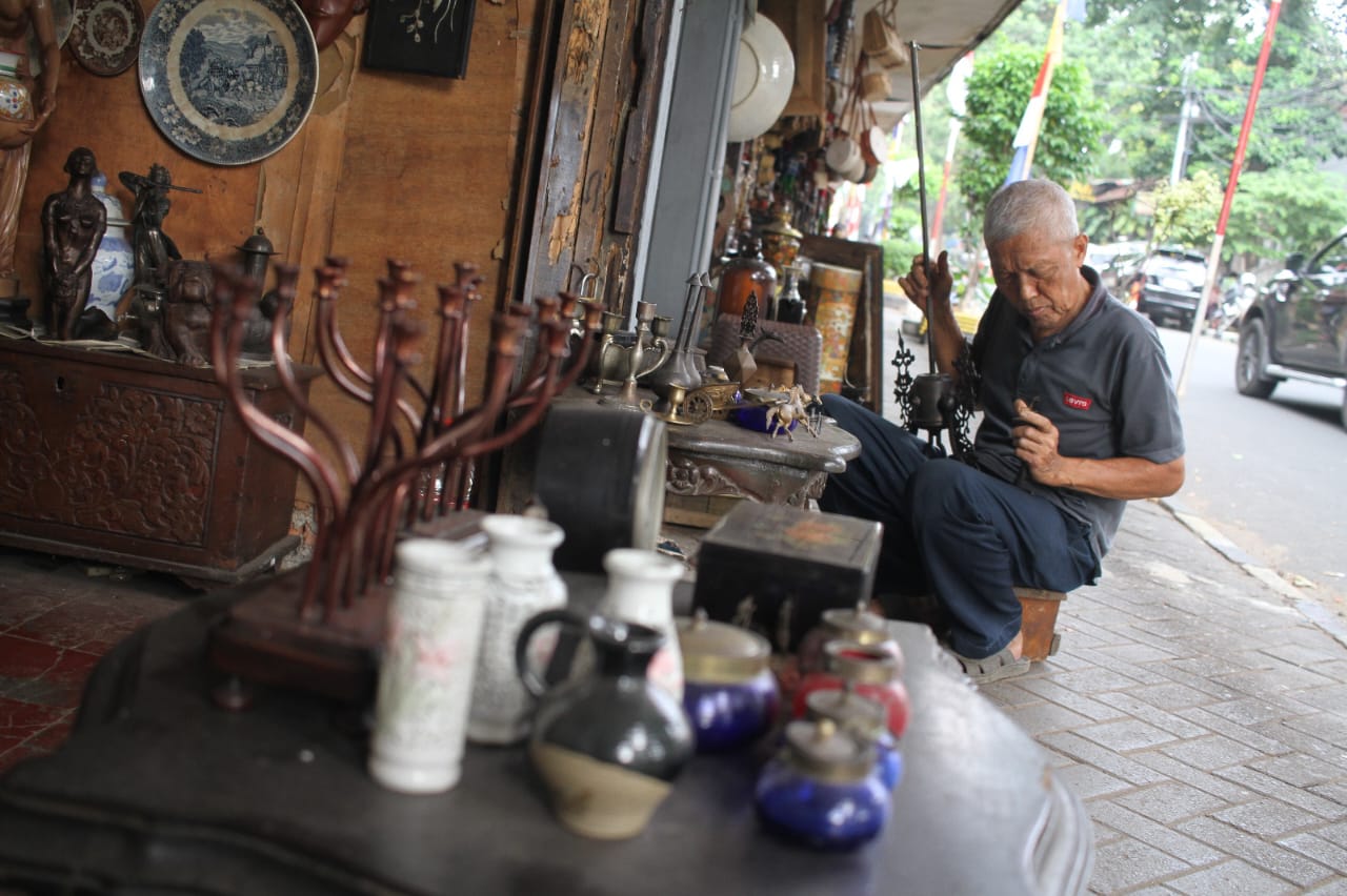 Penjual membersihkan barang dagangannya di Sentra Penjualan Barang Antik Jalan Surabaya, Menteng, Jakarta, Kamis (21/8/2025).  (Beritanasional.com/Oke Atmaja)