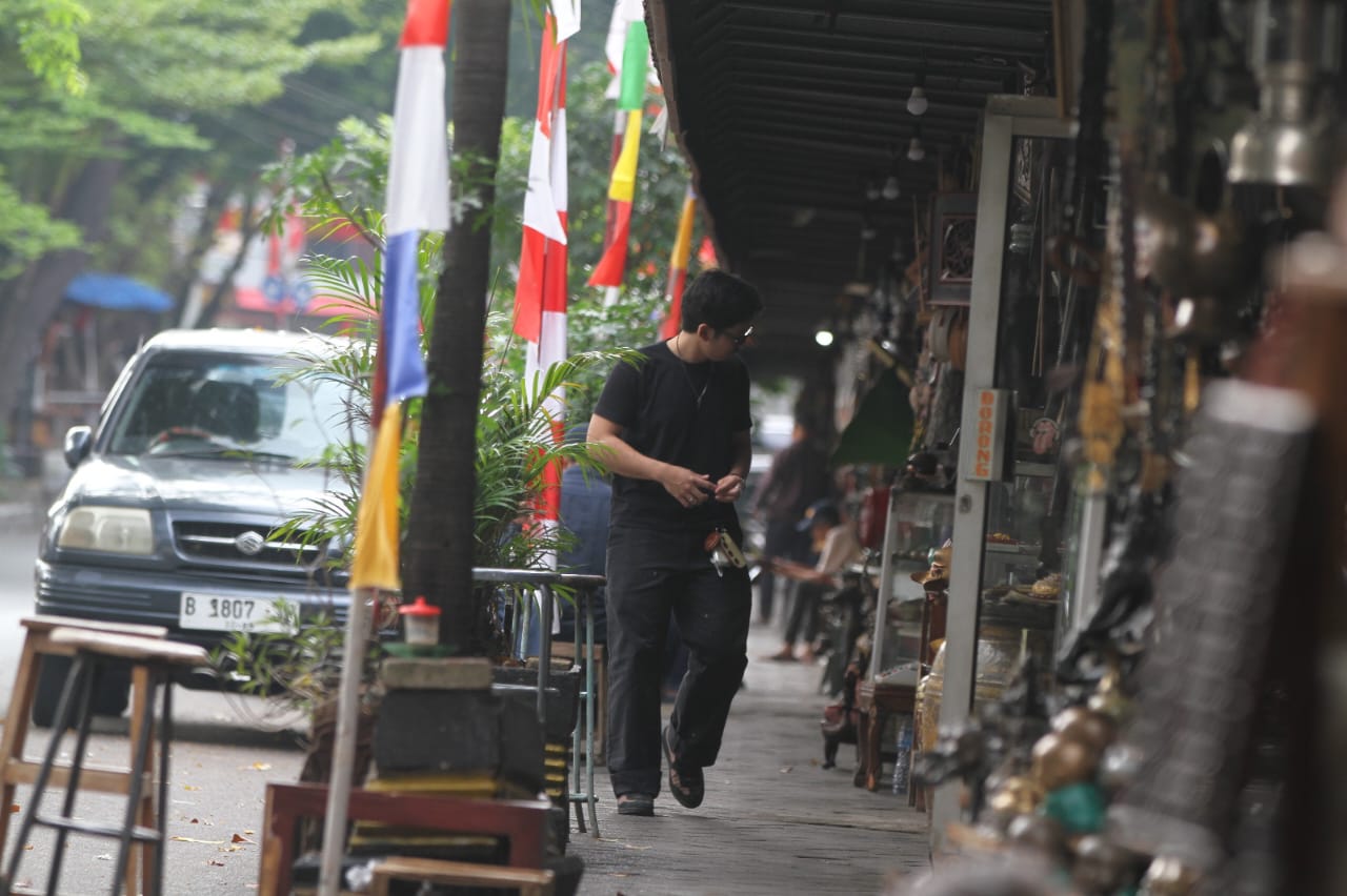 Penjual membersihkan barang dagangannya di Sentra Penjualan Barang Antik Jalan Surabaya, Menteng, Jakarta, Kamis (21/8/2025).  (Beritanasional.com/Oke Atmaja)