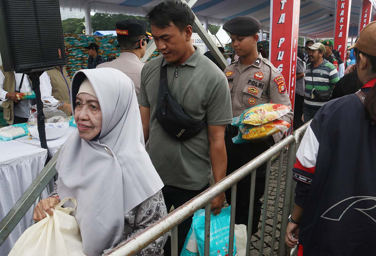 Petugas melayani warga yang mengambil paket sembako pada Pasar Murah untuk Rakyat di kawasan Monas, Jakarta, Sabtu (28/3/2026).  (Beritanasional.com/Oke Atmaja)