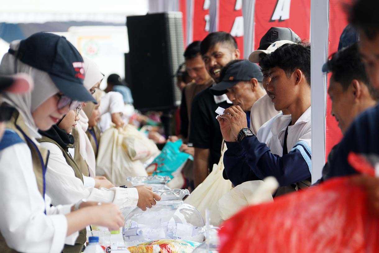 Petugas melayani warga yang mengambil paket sembako pada Pasar Murah untuk Rakyat di kawasan Monas, Jakarta, Sabtu (28/3/2026).  (Beritanasional.com/Oke Atmaja)