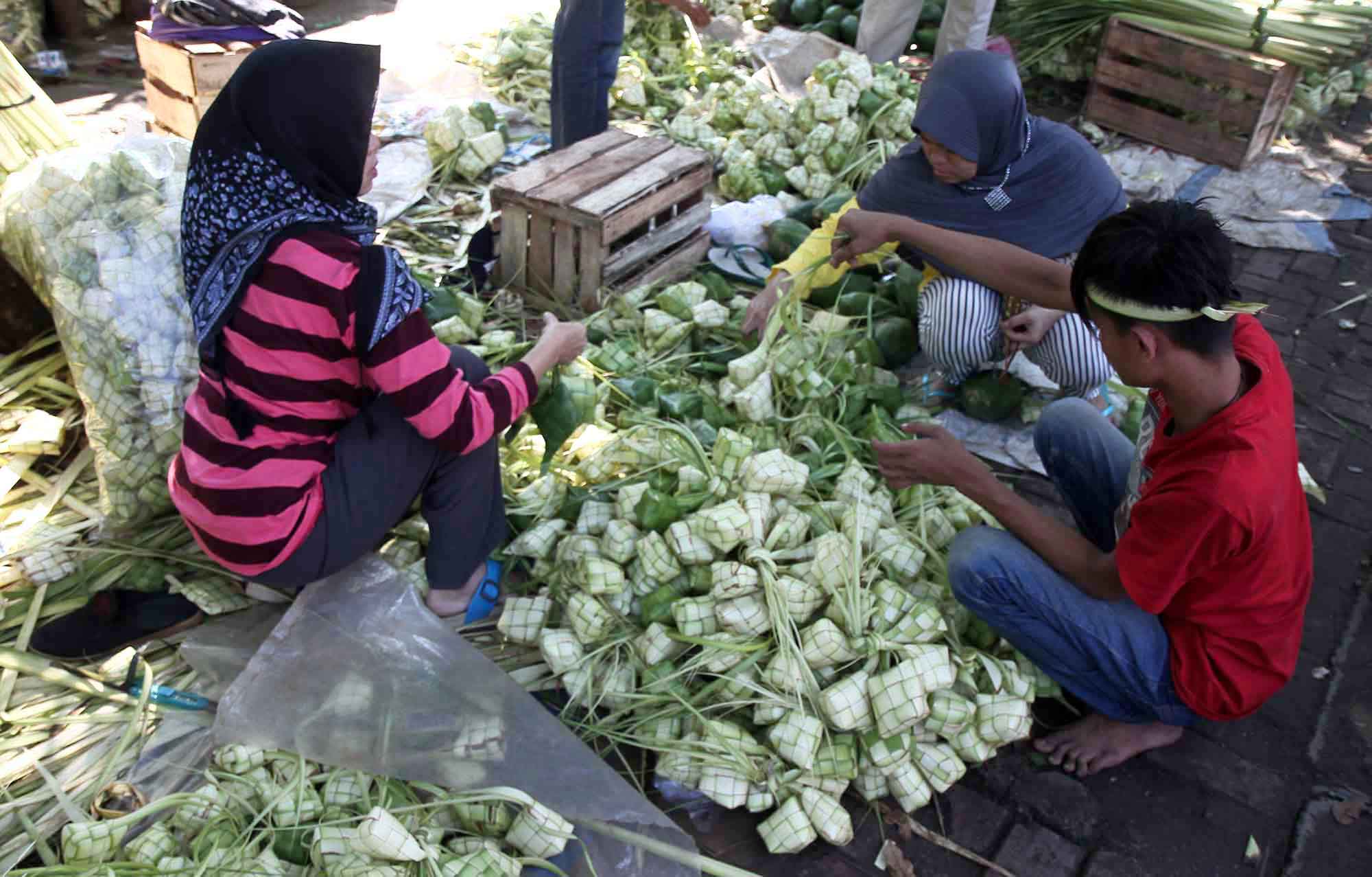 Pembeli memilih bungkus ketupat di Pasar Palmerah, Jakarta, Kamis (5/6/2025).  (Beritanasional.com/Oke Atmaja)