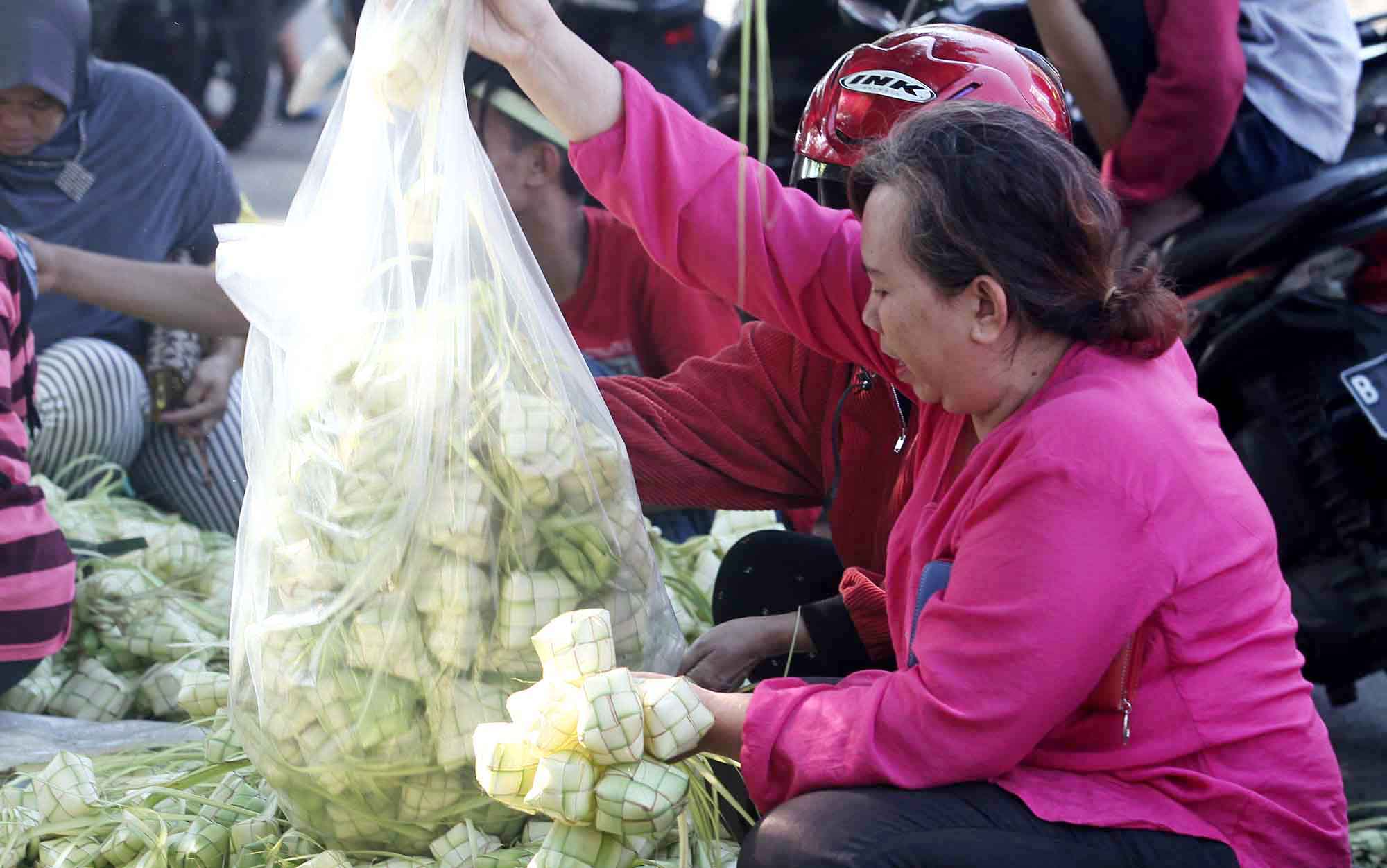 Pembeli memilih bungkus ketupat di Pasar Palmerah, Jakarta, Kamis (5/6/2025).  (Beritanasional.com/Oke Atmaja)
