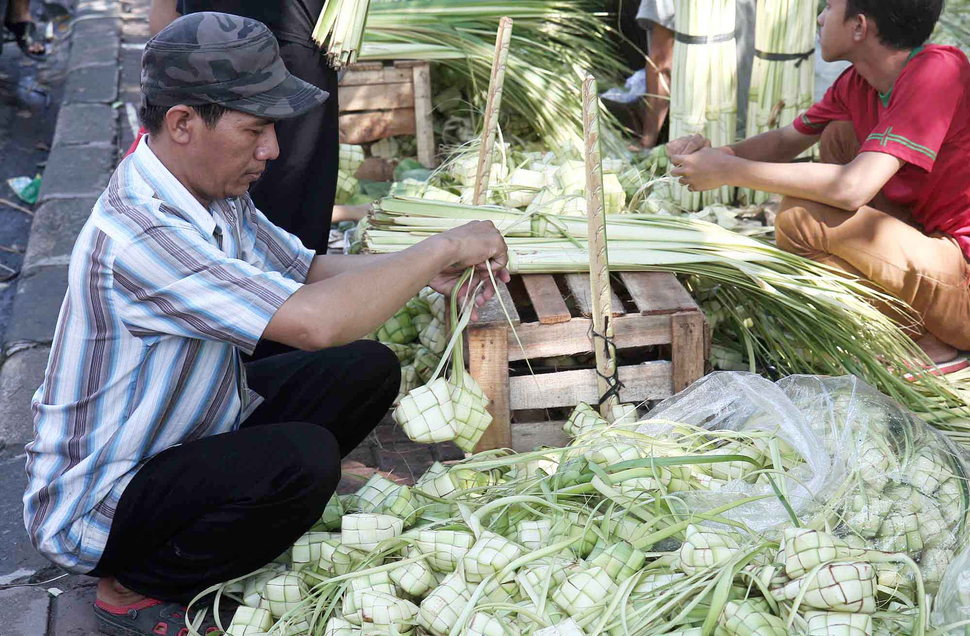 Pembeli memilih bungkus ketupat di Pasar Palmerah, Jakarta, Kamis (5/6/2025).  (Beritanasional.com/Oke Atmaja)