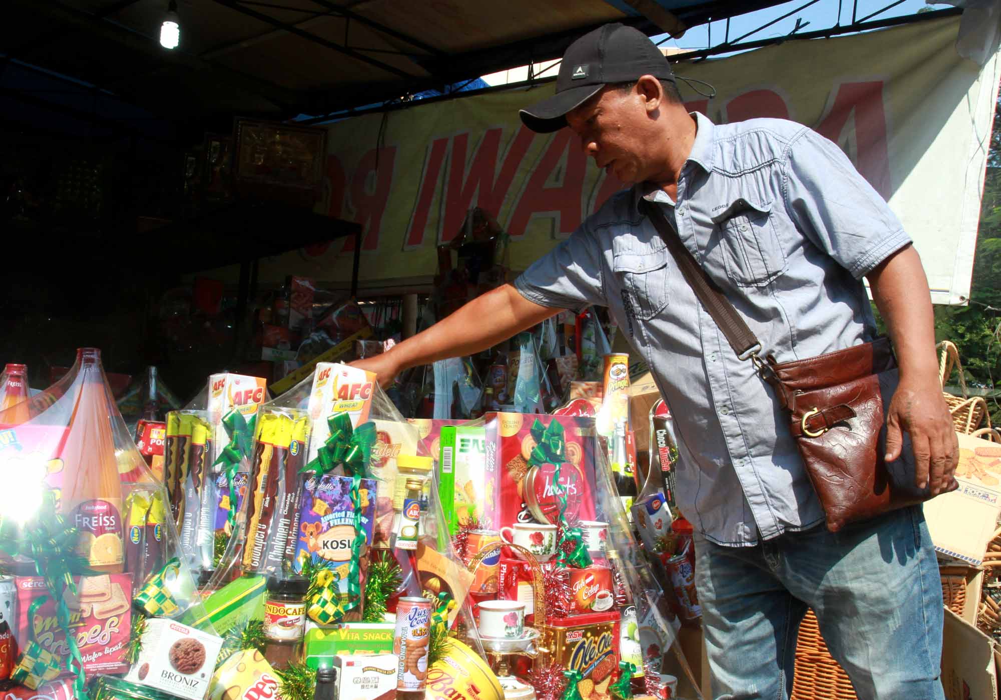 Pedagang menyelesaikan pembuatan parsel Lebaran berisi produk makanan ringan di Pasar Kembang, Cikini, Jakarta, Rabu (22/3/2024). (IndonesiaGlobe/Oke Atmaja)