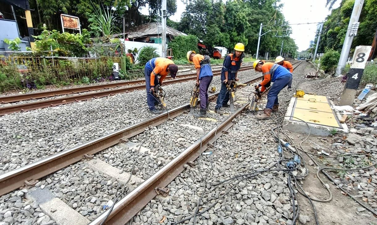 Petugas PT KAI menggunakan alat berat melakukan pemadatan batu kerikil rel kereta,Jakarta, Selasa (11/11/2025).  (Beritanasional.com/Oke Atmaja)