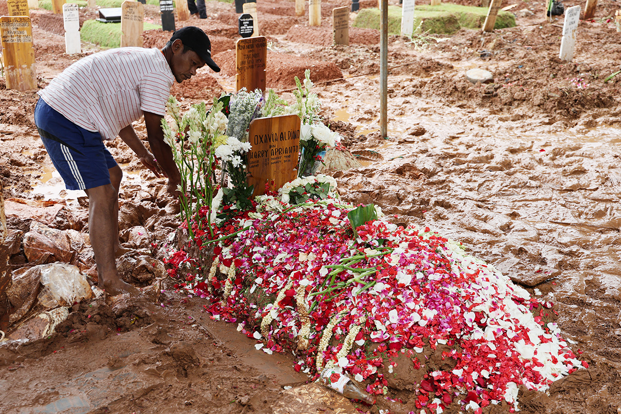 Pekerja kuburan merapikan Buga makam mendiang penyanyi Oxavia Aldiano atau Vidi Aldiano saat pemakaman di TPU Tanah Kusir, Jakarta, Minggu (8/3/2026).  (Beritanasional.com/Oke Atmaja)