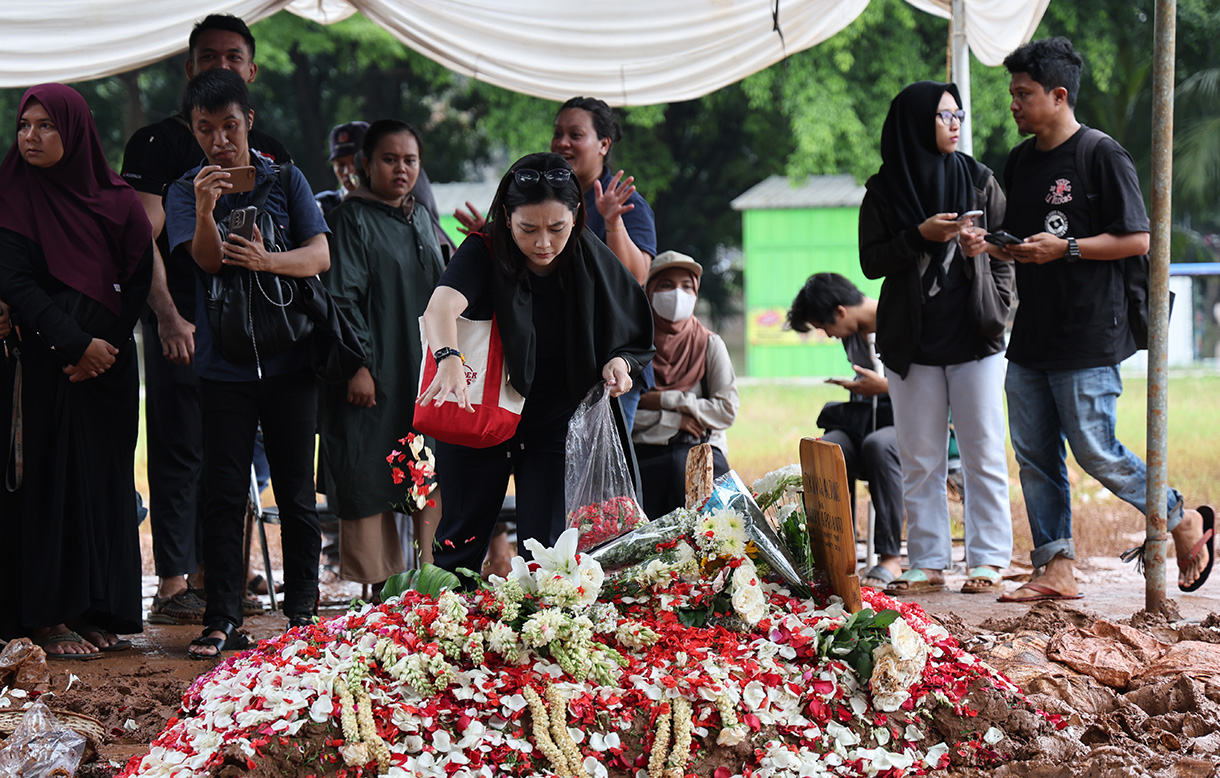 Pekerja kuburan merapikan Buga makam mendiang penyanyi Oxavia Aldiano atau Vidi Aldiano saat pemakaman di TPU Tanah Kusir, Jakarta, Minggu (8/3/2026).  (Beritanasional.com/Oke Atmaja)