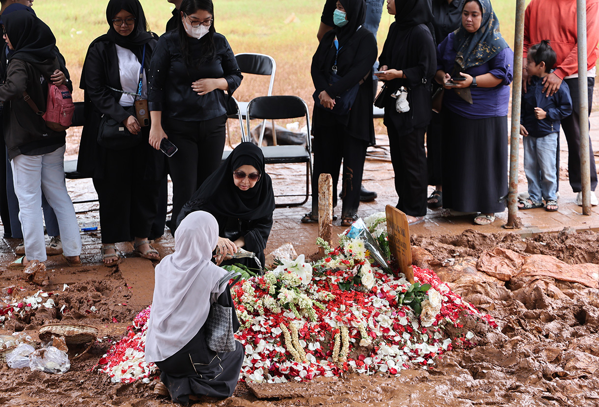 Pekerja kuburan merapikan Buga makam mendiang penyanyi Oxavia Aldiano atau Vidi Aldiano saat pemakaman di TPU Tanah Kusir, Jakarta, Minggu (8/3/2026).  (Beritanasional.com/Oke Atmaja)