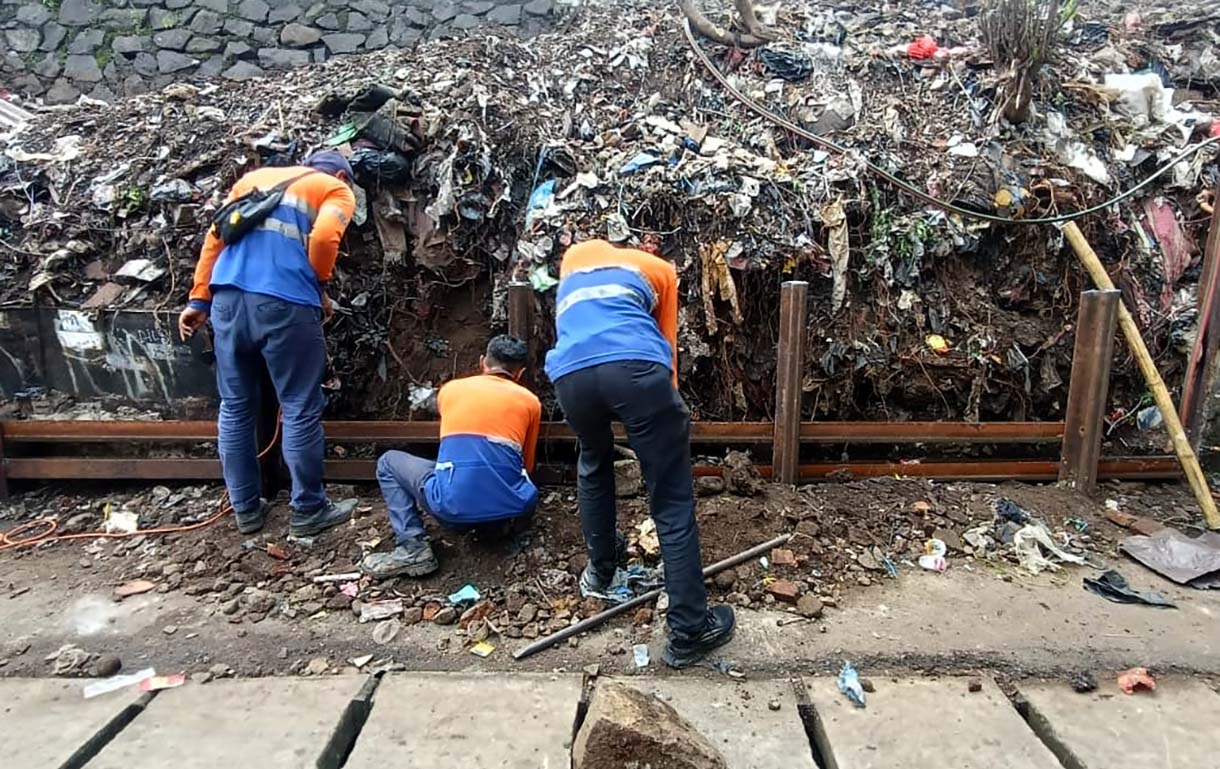 Petugas memasang besi rel kereta api untuk menahan tanah longsor di Kawasan Menteng, Jakarta Pusat, Minggu (23/11/2025).  (Beritanasional.com/Oke Atmaja)