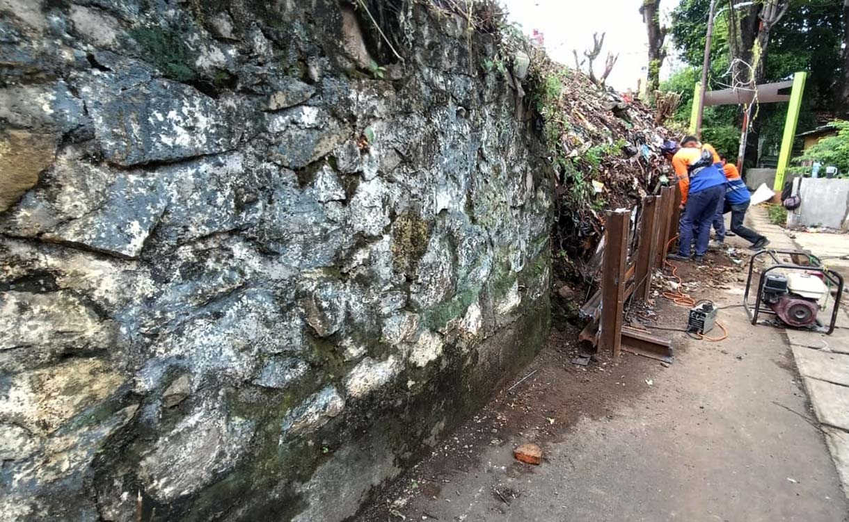 Petugas memasang besi rel kereta api untuk menahan tanah longsor di Kawasan Menteng, Jakarta Pusat, Minggu (23/11/2025).  (Beritanasional.com/Oke Atmaja)