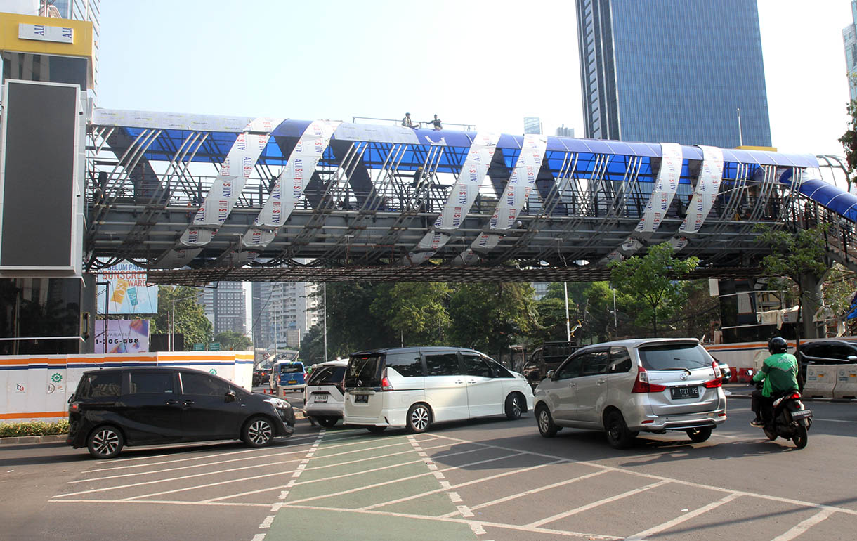 Sejumlah kendaraan melintasi pembangunan jembatan penyeberangan orang (JPO) di Jalan KH Mas Mansyur, Tanah Abang, Jakarta Pusat, Sabtu(26/10/2024). (BeritaNasional.com/Oke Atmaja)