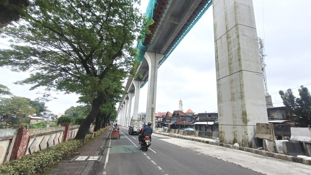 kendaraan melintas disamping pembangunan jalur Light Rail Transit (LRT) Jakarta Fase 1B berlangsung di Manggarai, Jakarta, Kamis (26/3/2026).  (Beritanasional.com/Oke Atmaja)