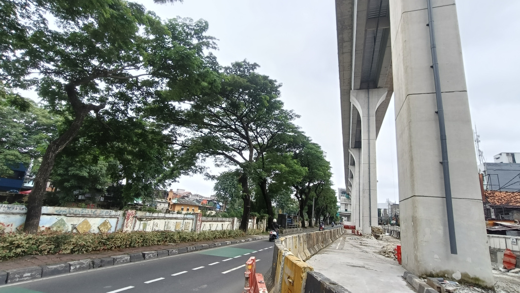 kendaraan melintas disamping pembangunan jalur Light Rail Transit (LRT) Jakarta Fase 1B berlangsung di Manggarai, Jakarta, Kamis (26/3/2026).  (Beritanasional.com/Oke Atmaja)