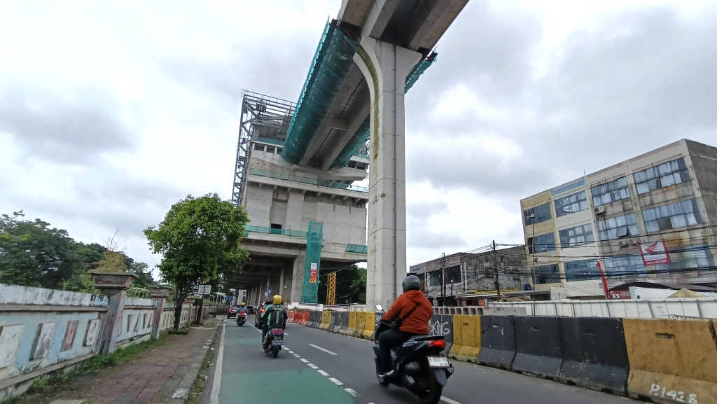 kendaraan melintas disamping pembangunan jalur Light Rail Transit (LRT) Jakarta Fase 1B berlangsung di Manggarai, Jakarta, Kamis (26/3/2026).  (Beritanasional.com/Oke Atmaja)
