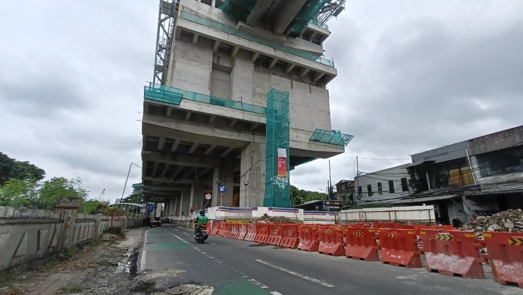 kendaraan melintas disamping pembangunan jalur Light Rail Transit (LRT) Jakarta Fase 1B berlangsung di Manggarai, Jakarta, Kamis (26/3/2026).  (Beritanasional.com/Oke Atmaja)