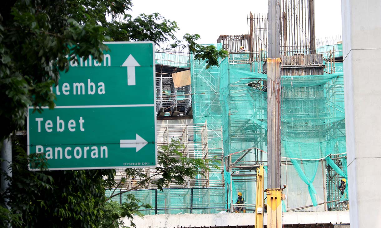 Kendaraan melintas disamping proyek pembangunan Light Rail Transit (LRT) Jakarta Fase 1B yang menghubungkan Velodrome ke Manggarai, di Jalan Tambak, Manggarai, Jakarta, Selasa (21/10/2025).(Beritanasional.com/Okeatmaja)