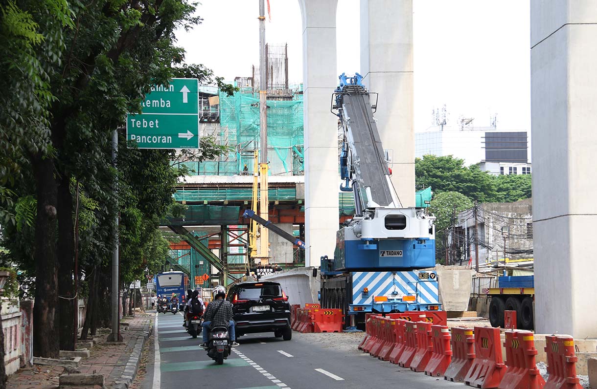 Kendaraan melintas disamping proyek pembangunan Light Rail Transit (LRT) Jakarta Fase 1B yang menghubungkan Velodrome ke Manggarai, di Jalan Tambak, Manggarai, Jakarta, Selasa (21/10/2025).(Beritanasional.com/Okeatmaja)