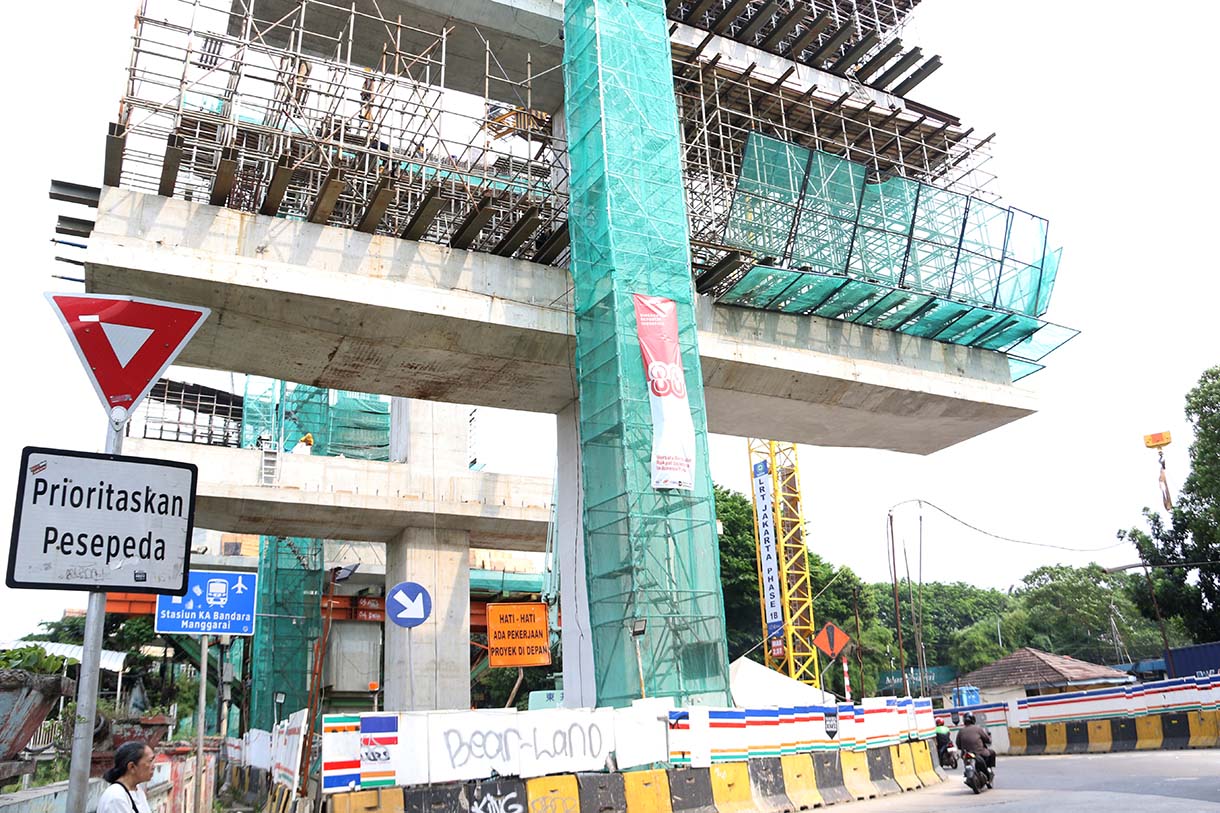 Kendaraan melintas disamping proyek pembangunan Light Rail Transit (LRT) Jakarta Fase 1B yang menghubungkan Velodrome ke Manggarai, di Jalan Tambak, Manggarai, Jakarta, Selasa (21/10/2025).(Beritanasional.com/Okeatmaja)