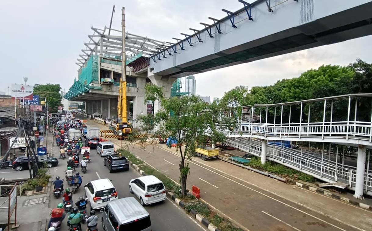 Kendaraan melintas di dekat proyek pembangunan jalur LRT Jakarta Fase 1B yang akan tersambung di atas Jalan Layang Pemuda, Jakarta, Senin (24/11/2025).  (Beritanasional.com/Oke Atmaja)