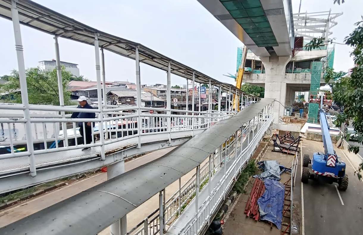 Kendaraan melintas di dekat proyek pembangunan jalur LRT Jakarta Fase 1B yang akan tersambung di atas Jalan Layang Pemuda, Jakarta, Senin (24/11/2025).  (Beritanasional.com/Oke Atmaja)