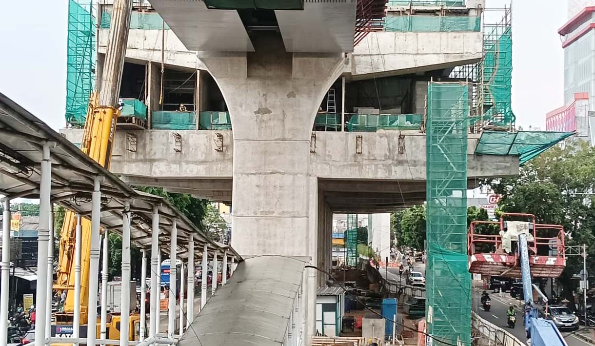 Kendaraan melintas di dekat proyek pembangunan jalur LRT Jakarta Fase 1B yang akan tersambung di atas Jalan Layang Pemuda, Jakarta, Senin (24/11/2025).  (Beritanasional.com/Oke Atmaja)