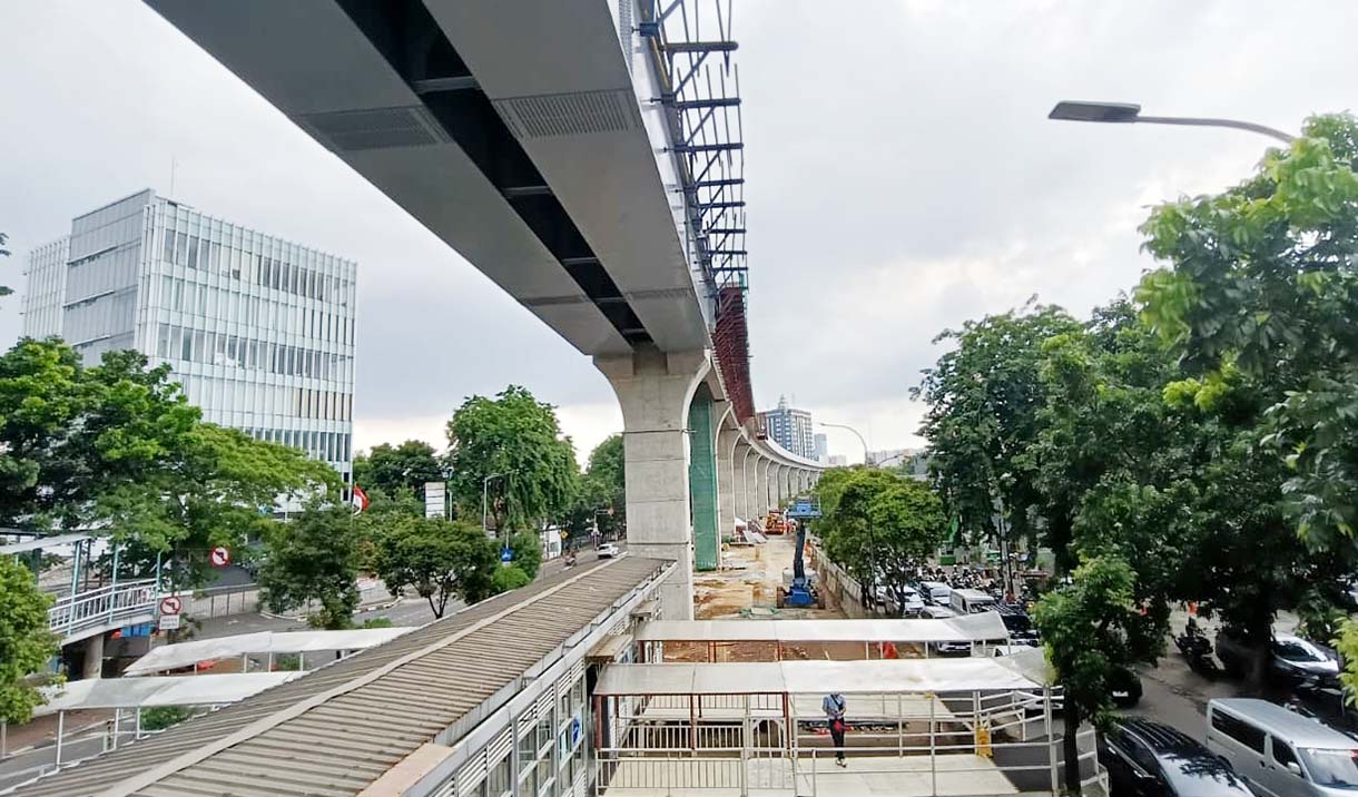 Kendaraan melintas di dekat proyek pembangunan jalur LRT Jakarta Fase 1B yang akan tersambung di atas Jalan Layang Pemuda, Jakarta, Senin (24/11/2025).  (Beritanasional.com/Oke Atmaja)