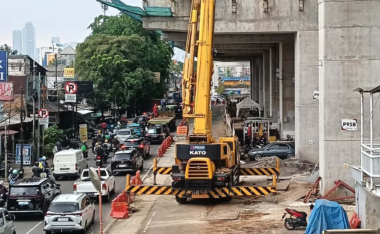 Kendaraan melintas di dekat proyek pembangunan jalur LRT Jakarta Fase 1B yang akan tersambung di atas Jalan Layang Pemuda, Jakarta, Senin (24/11/2025).  (Beritanasional.com/Oke Atmaja)