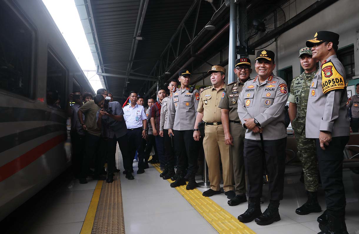 Petugas merapikan motor penumpang peserta layanan Angkutan Motor Gratis dengan Kereta Api (Motis) di dalam gerbong kereta api di Stasiun Pasar Senen, Jakarta, Selasa (23/12/2025).  (Beritanasional.com/Oke Atmaja)