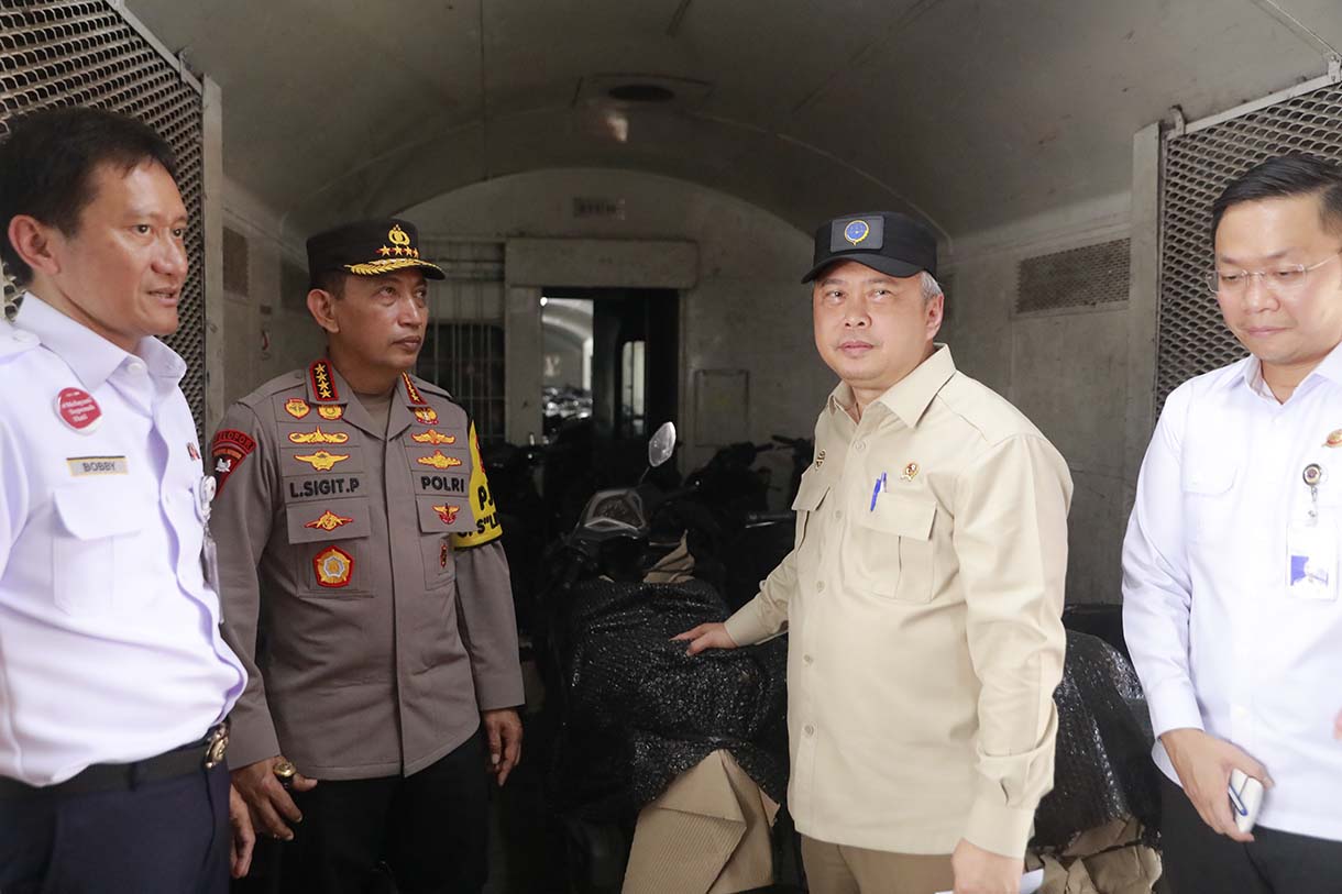 Petugas merapikan motor penumpang peserta layanan Angkutan Motor Gratis dengan Kereta Api (Motis) di dalam gerbong kereta api di Stasiun Pasar Senen, Jakarta, Selasa (23/12/2025).  (Beritanasional.com/Oke Atmaja)