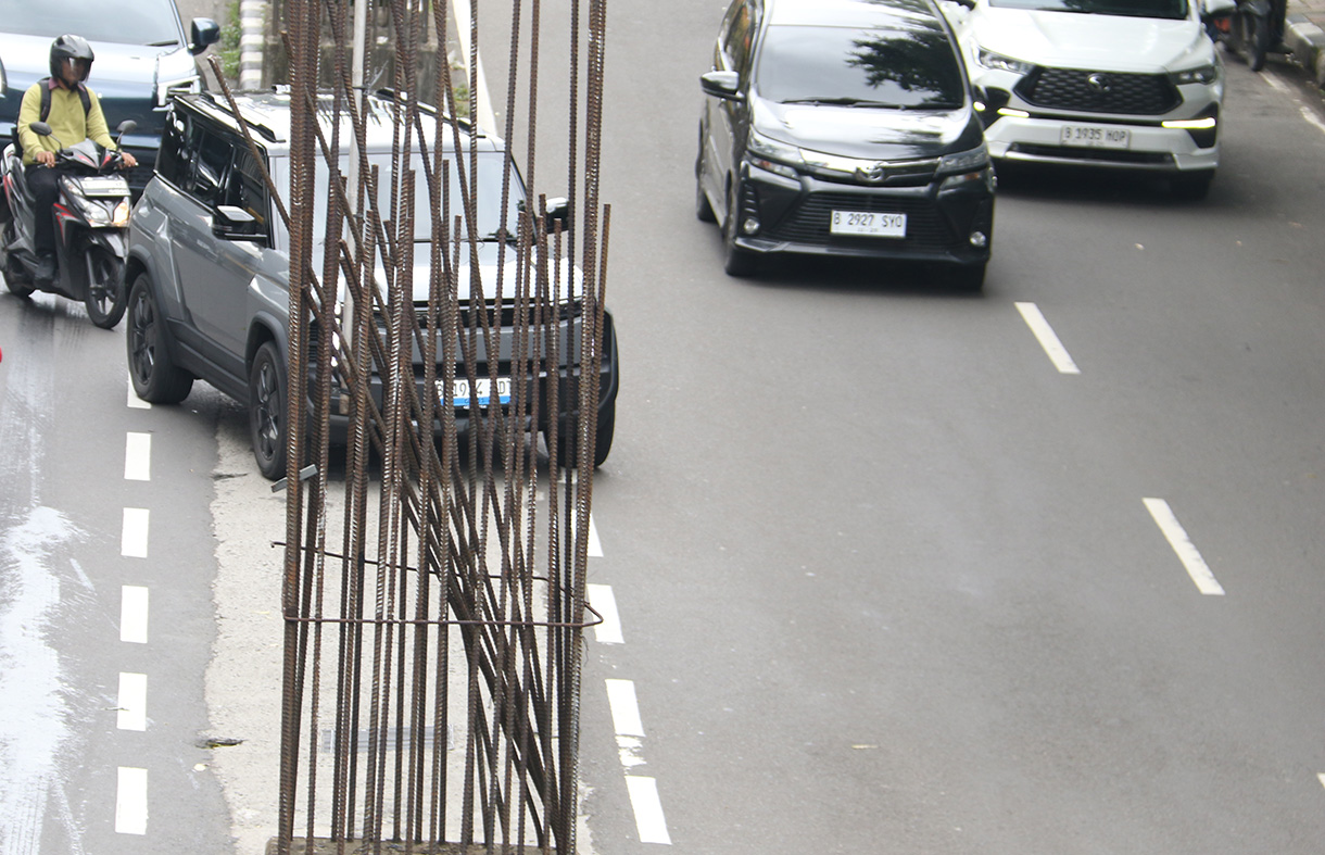 Kendaraan melintas di deretan tiang monorel yang masih dalam proses pembongkaran di Jalan HR Rasuna Said, Jakarta, Selasa (27/1/2026).(Beritanasional.com/Oke Atmaja)