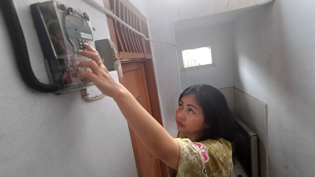 Pemerintah Memberlakukan Diskon Tarif Listrik 50 Persen Warga memeriksa meteran listrik di rumahnya, Jakarta, Kamis (5/6/2025). (Beritanasional.com/ Oke Atmaja)