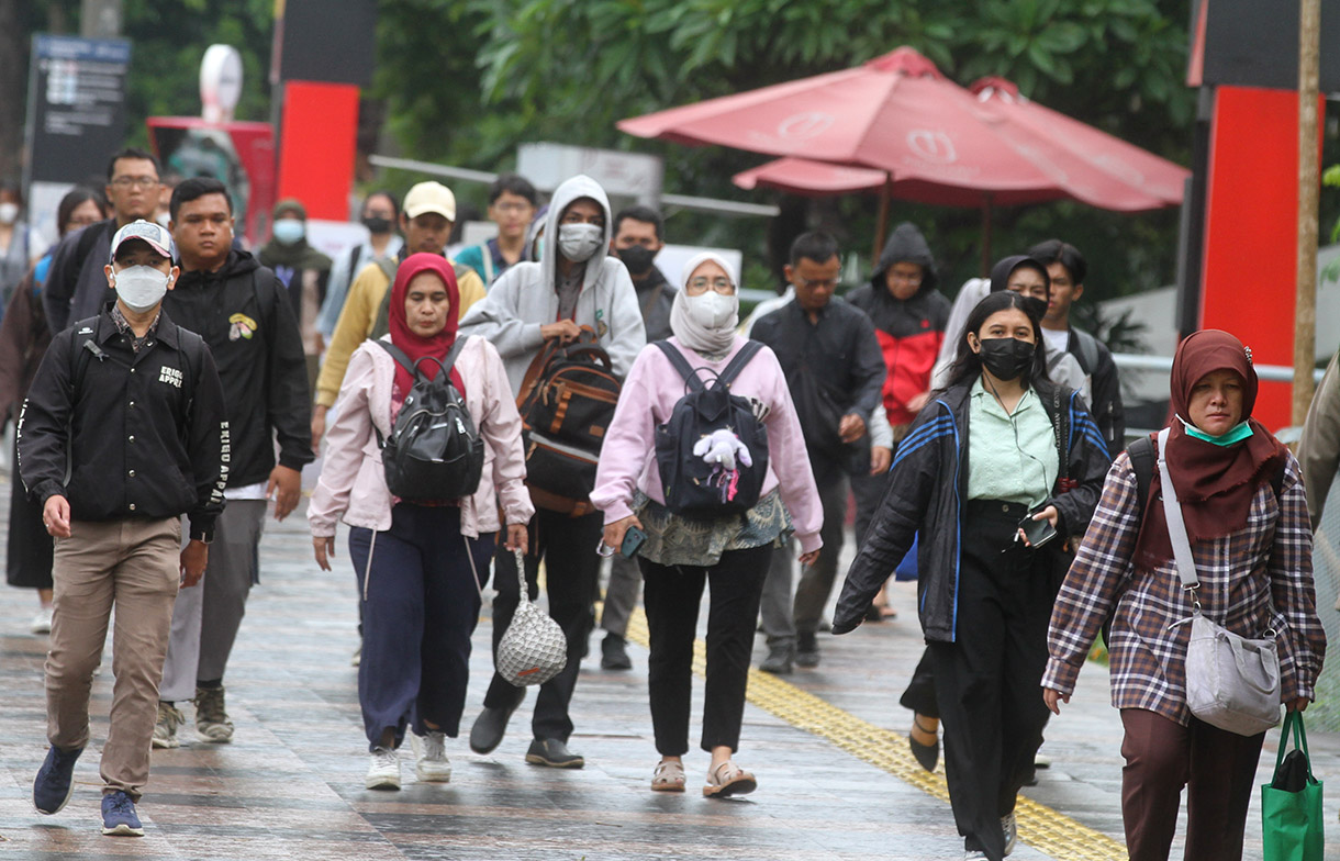 Pekerja melintasi pedestrian di kawasan Jalan Jenderal Sudirman, Jakarta, Rabu (8/1/2025).(BeritaNasional.com/Oke Atmaja)