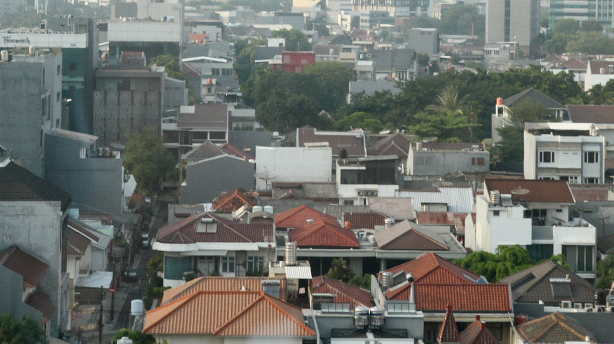 Foto udara pemukiman dengan latar belakang gedung bertingkat di kawasan Jakarta, Kamis (12/9/2024). (BeritaNasional.com/ Oke Atmaja)