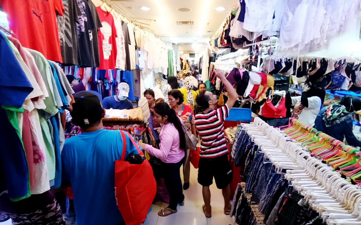 Calon pembeli memilih pakaian bekas yang dijual di salah satu toko di Pasar Senen, Jakarta, Selasa (30/12/2025). (Beritanasional.com/Oke Atmaja)