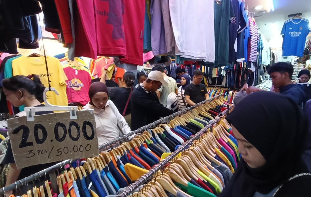 Calon pembeli memilih pakaian bekas yang dijual di salah satu toko di Pasar Senen, Jakarta, Selasa (30/12/2025). (Beritanasional.com/Oke Atmaja)