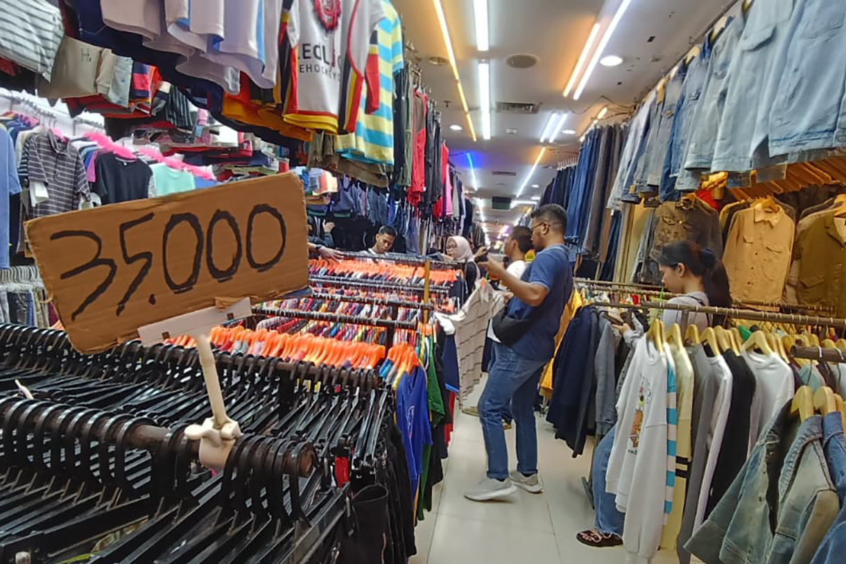Calon pembeli memilih pakaian bekas yang dijual di salah satu toko di Pasar Senen, Jakarta, Selasa (30/12/2025). (Beritanasional.com/Oke Atmaja)