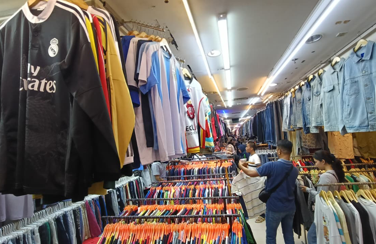 Calon pembeli memilih pakaian bekas yang dijual di salah satu toko di Pasar Senen, Jakarta, Selasa (30/12/2025). (Beritanasional.com/Oke Atmaja)