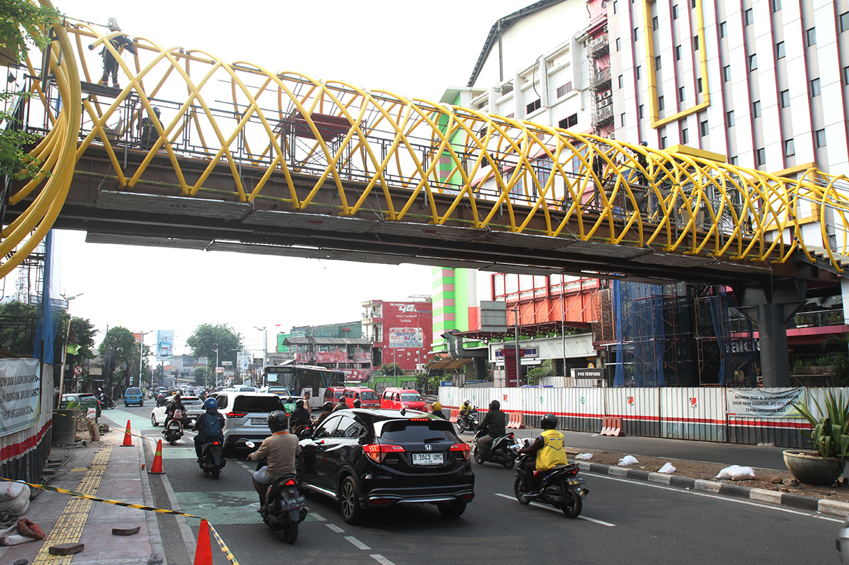 Kendaraan melintas di dekat proyek pembangunan jembatan penyeberangan orang (JPO) PGC Cililitan, Jakarta, Jakarta, Selasa (19/8/2024).(BeritaNasional.com/ Oke Atmaja)