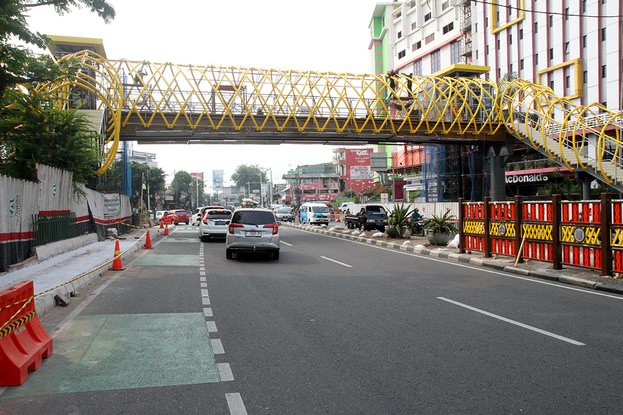 Kendaraan melintas di dekat proyek pembangunan jembatan penyeberangan orang (JPO) PGC Cililitan, Jakarta, Jakarta, Selasa (19/8/2024).(BeritaNasional.com/ Oke Atmaja)