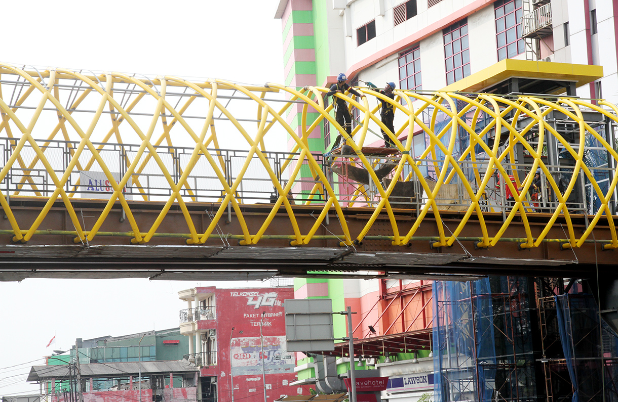 Kendaraan melintas di dekat proyek pembangunan jembatan penyeberangan orang (JPO) PGC Cililitan, Jakarta, Jakarta, Selasa (19/8/2024).(BeritaNasional.com/ Oke Atmaja)