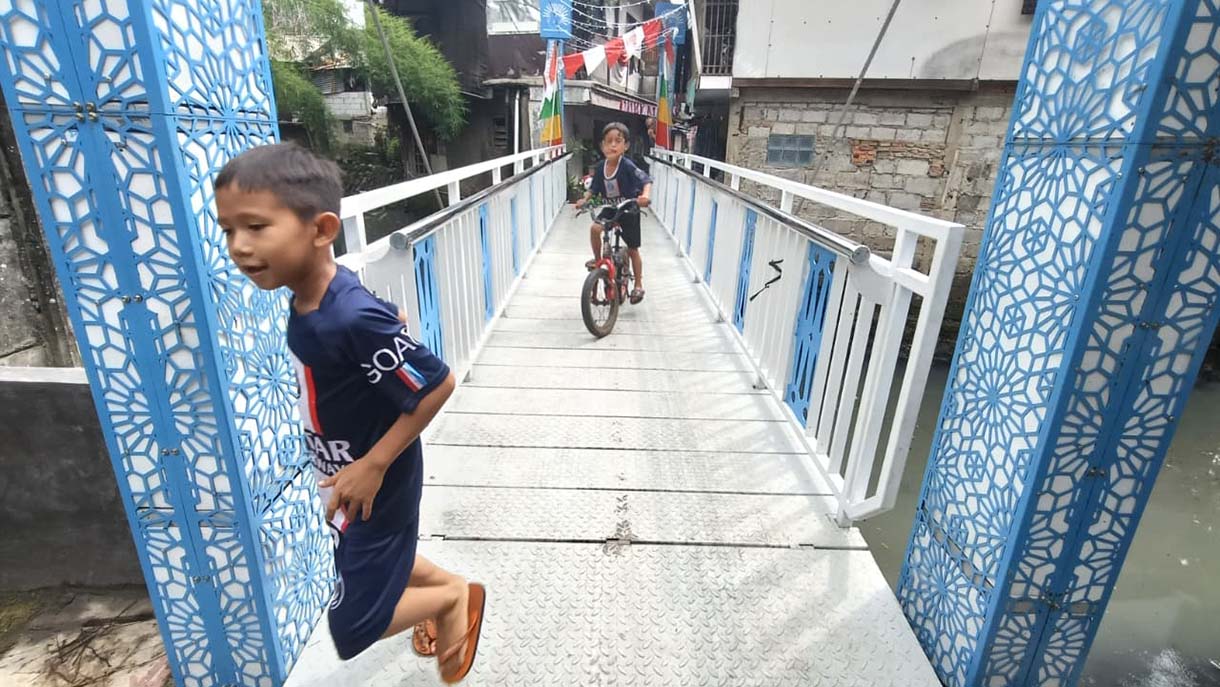 Pemprov DKI Bangun Jembatan Buka Tutup Warga melintas di Jembatan Antar Kampung (JAK) Angkat Mulia, Gandaria, Jakarta, Selasa(19/8/2025). (Beritanasional.com/Oke Atmaja)