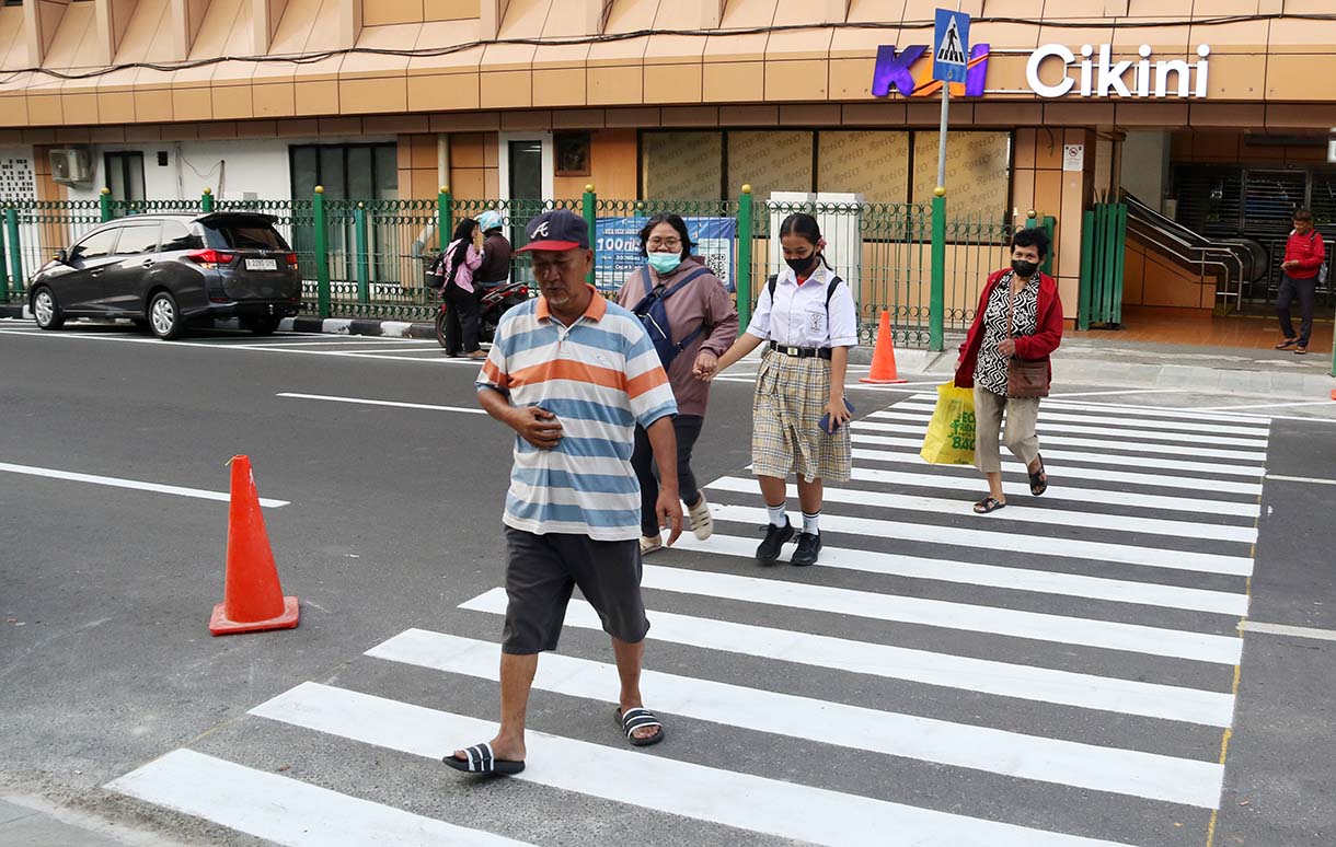 Warga menyeberang jalan menggunakan pelican crossing di sisi timur Stasiun Cikini, Jakarta, Senin (29/9/2025). (Beritanasional.com/Oke Atmaja)