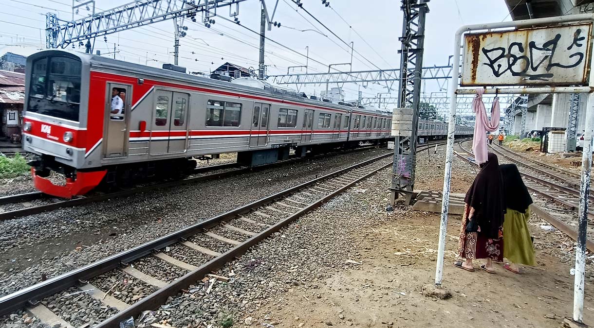 Pemprov DKI Jakarta akan Pasang Pagar Pembatas di Bantaran Rel Warga menyeberang rel kereta api di Kawasan Stasiun Manggarai, Jakarta, Minggu(4/5/2025). (Beritanasional.com/Oke Atmaja)
